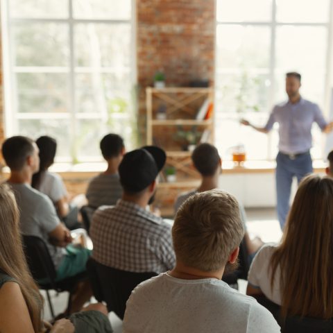 Male speaker giving presentation in hall at university workshop